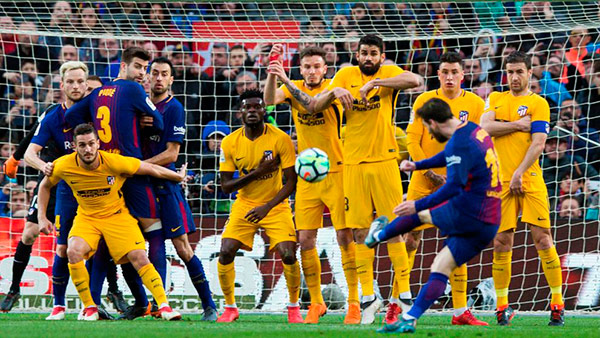 El delantero argentino del FC Barcelona Lionel Messi lanza el balón ante los jugadores del Atlético de Madrid. Foto: Enric Fontcuberta | EFE messi-barcelona-atletico-falta